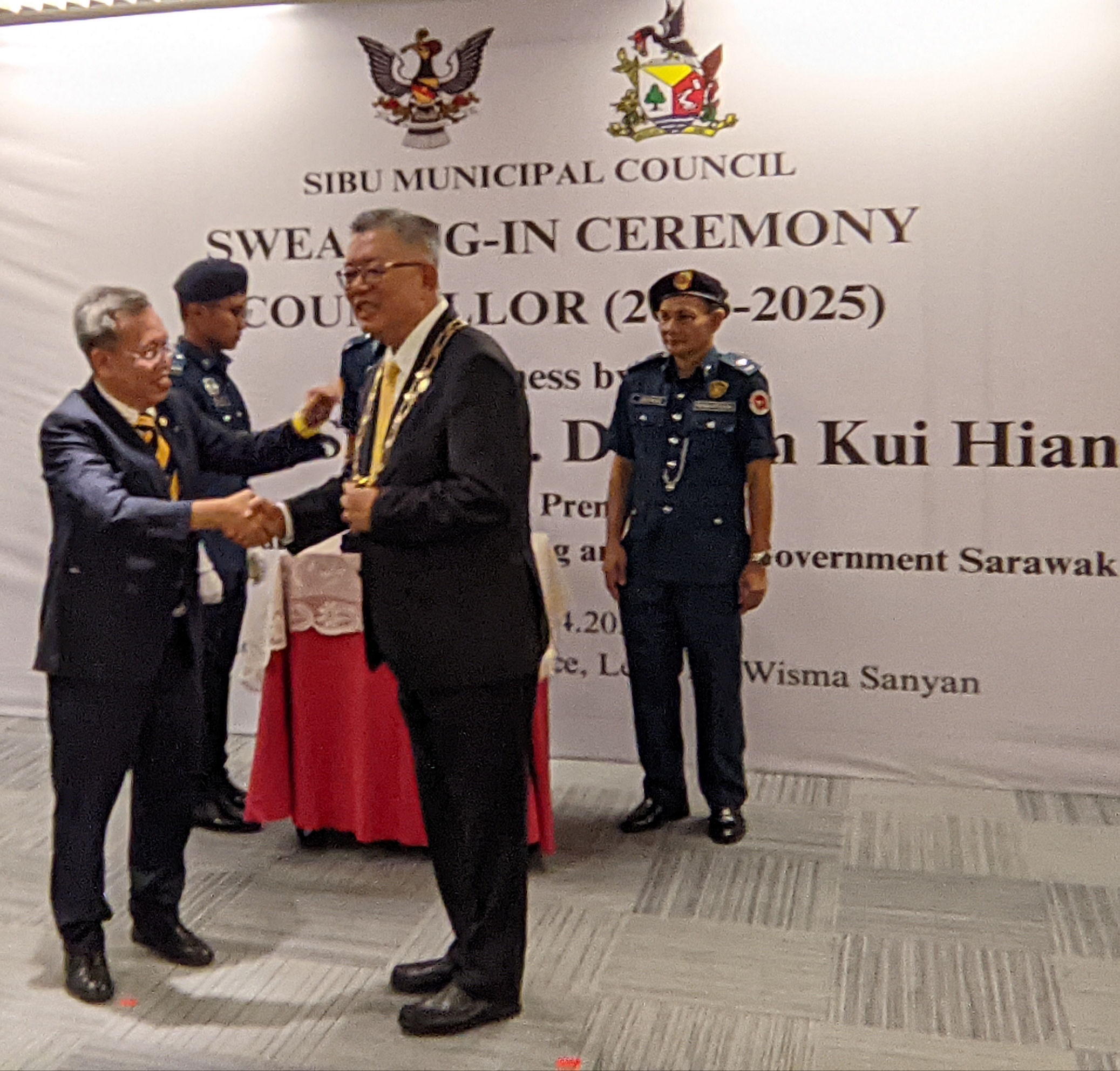 Ting (right) symbolically receives his reappointment as SMC chairman from Dr Sim.