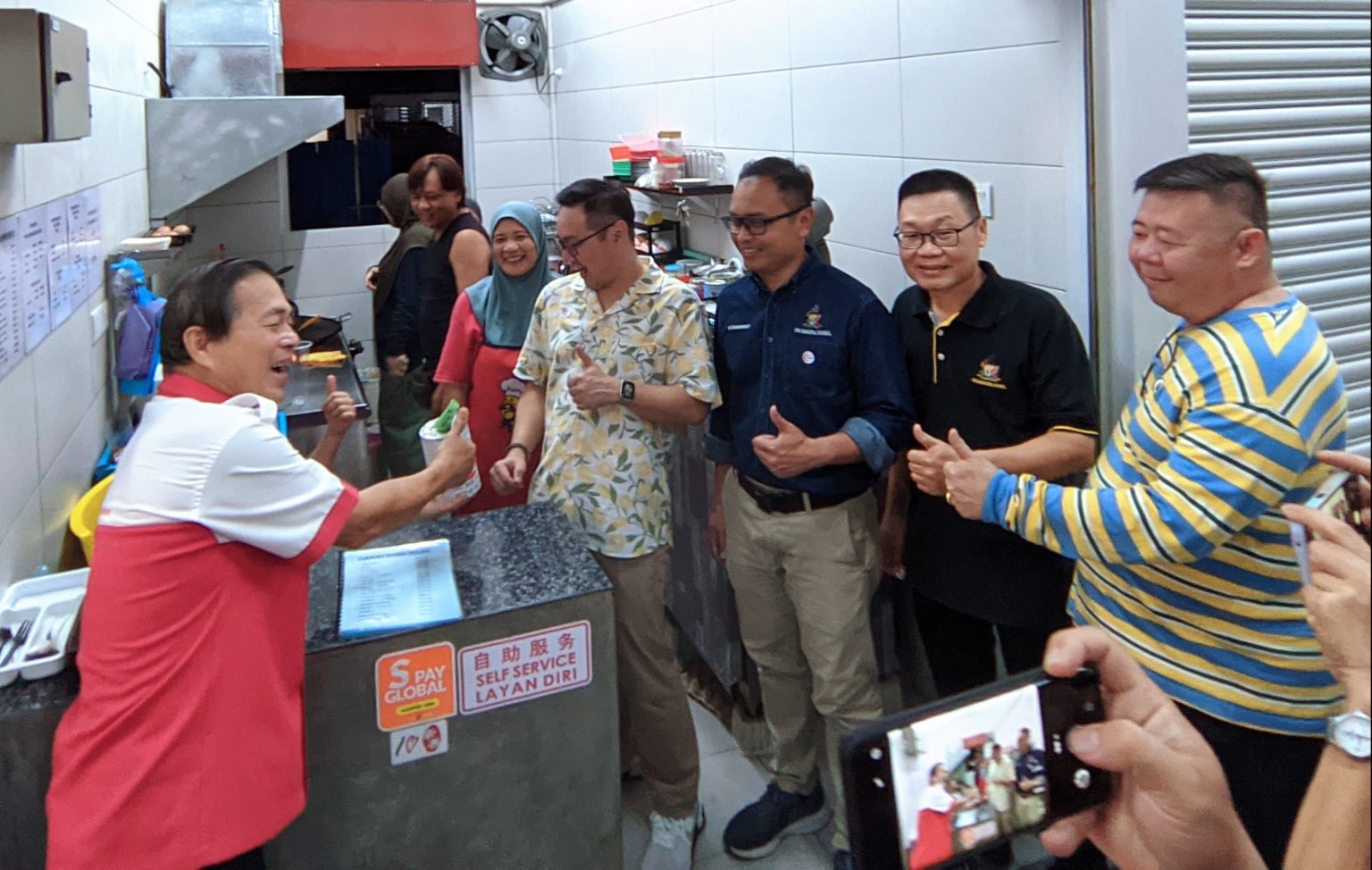 (From front left) Chua, Tiang, and Mohammed Abdullah are seen at a stall. – Photo by Peter Boon