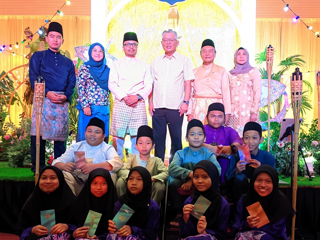 Abdullah Izkandar (on stage, third left) and Ting, on his left, join others in a photo session during SMC’s Aidilfitri gathering at Sibu Islamic Complex. – Photo by Peter Boon