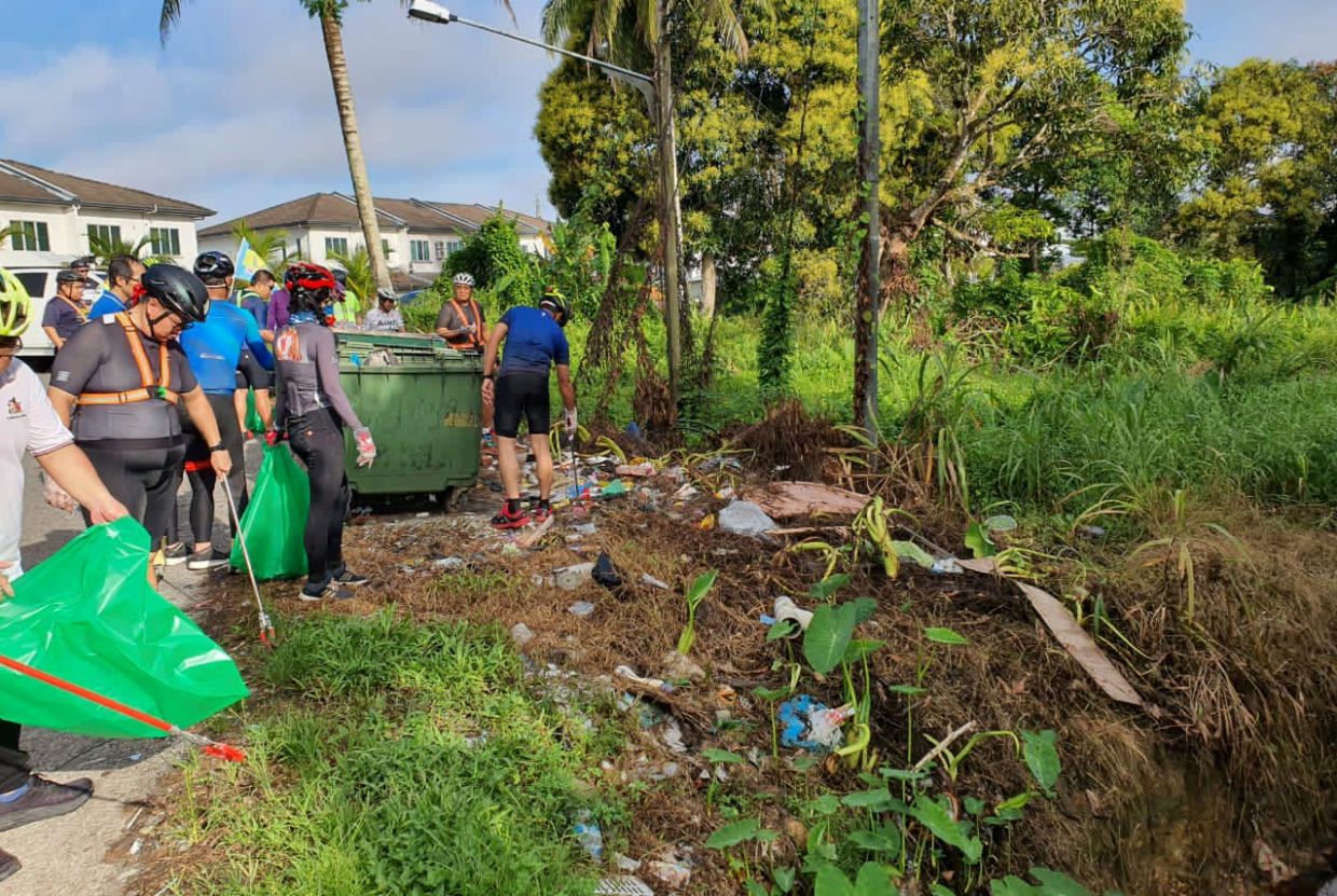 Participants of the riding event collecting trash by the road.