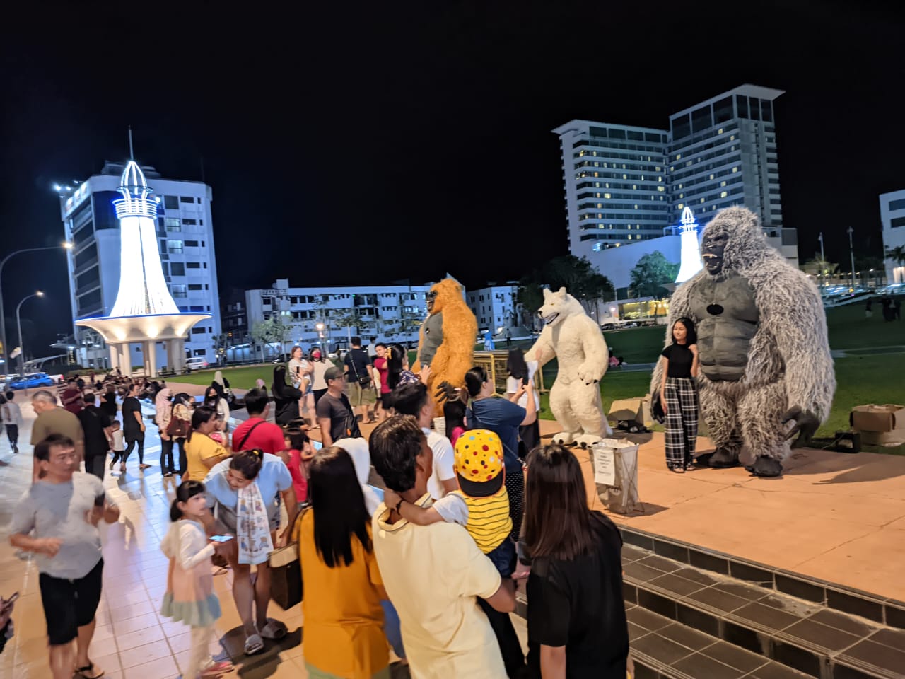 Adults and children are drawn to the three costumed performers. – Photo by Peter Boon