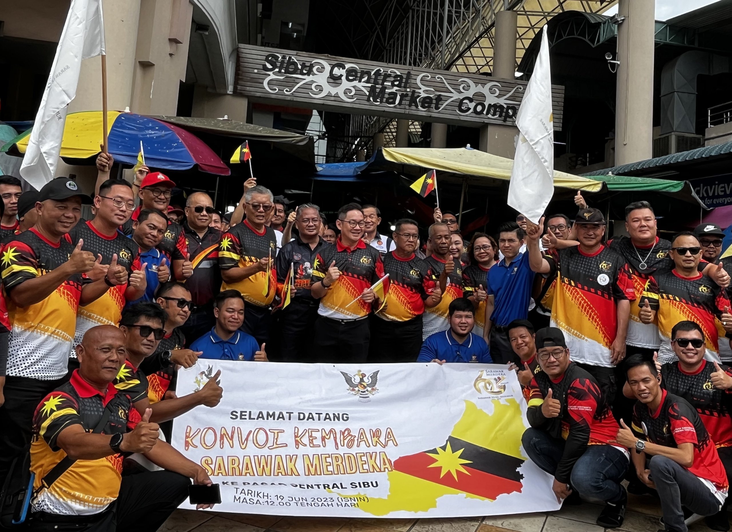 Tiang (standing front, centre) joins the convoy participants in a group photo at Sibu Central Market. Ting is on the same row, at sixth left.