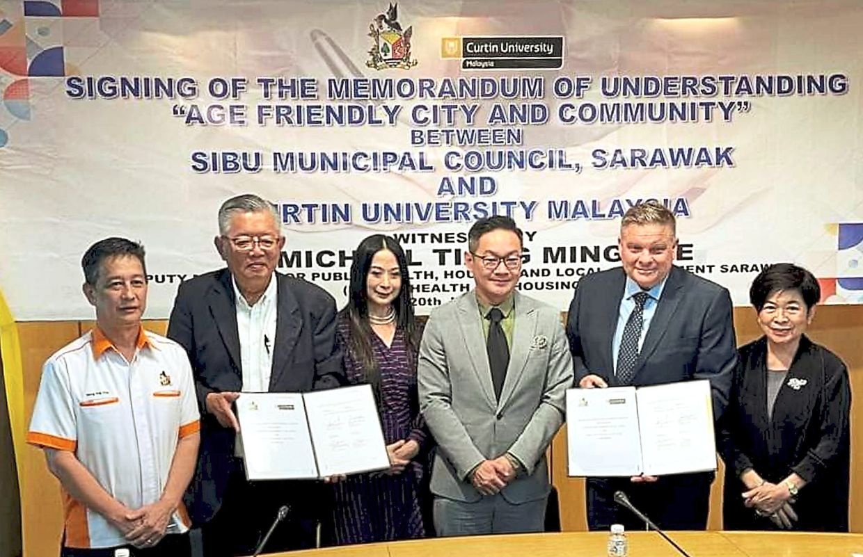 Prof Leunig (second from right) and Ting (second from left) showing the signed document witnessed by Tiang (third from right).