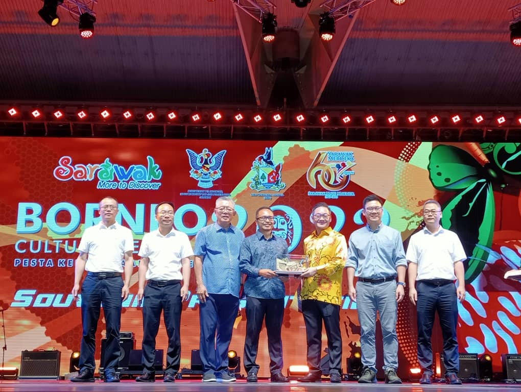 Abdullah Izkandar (centre) presents a memento to Tiang, witnessed by Ling (second right), Ting (third left) and others on stage.