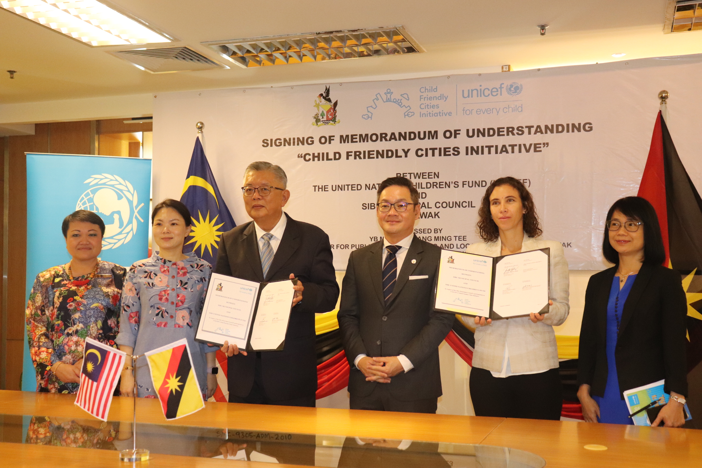 Ting and Escallon show the signed documents. From second left are Lau and Tiang. — Photo by Conny Banji