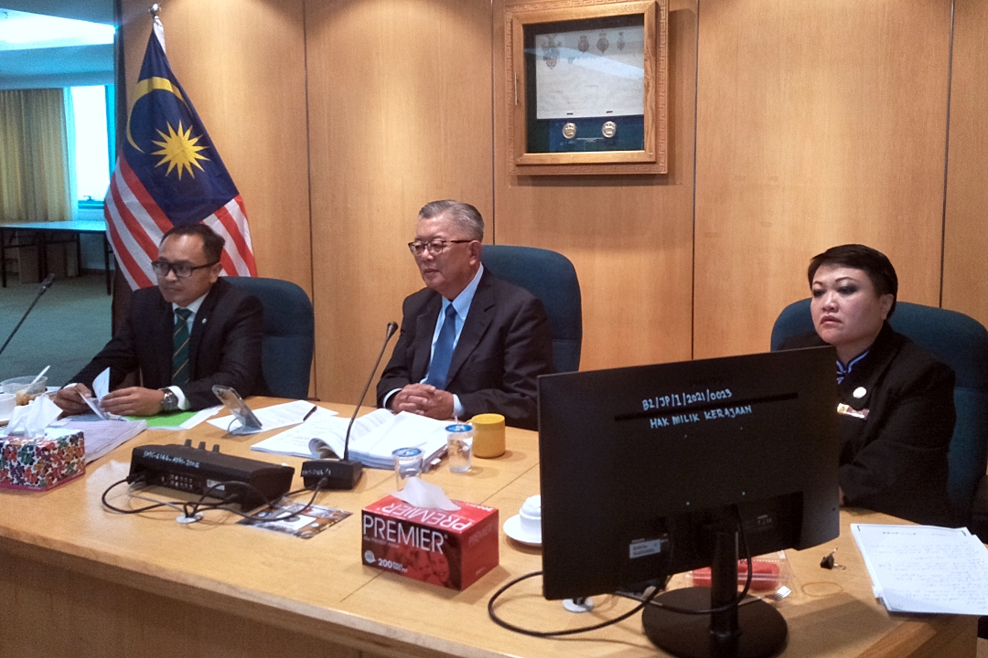 Ting (seated, centre) chairs the full council meeting. With him are Izkandar and SMC legal officer Jestina Teresa Kaben.