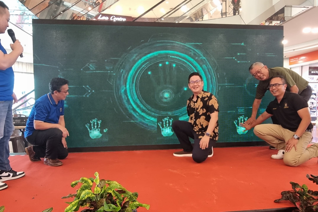 Tiang (center) does a symbolic gesture to officiate at SMC Innovation, Integrity Day cum The Customer Day 2023, while Izkandar (right) and Ting (behind Izkandar) and others look on.