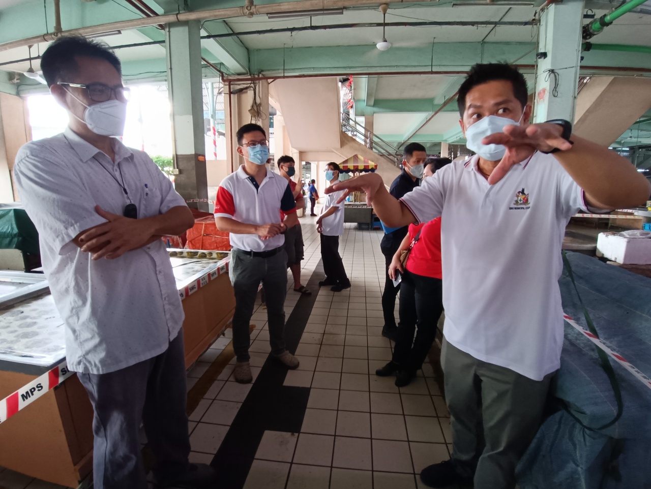 Tiang (right) in a discussion with Kenny Yu (left), the head contractor of the rewiring works on Sibu Central market. Ling is seen at second left. — Photo by Peter Boon