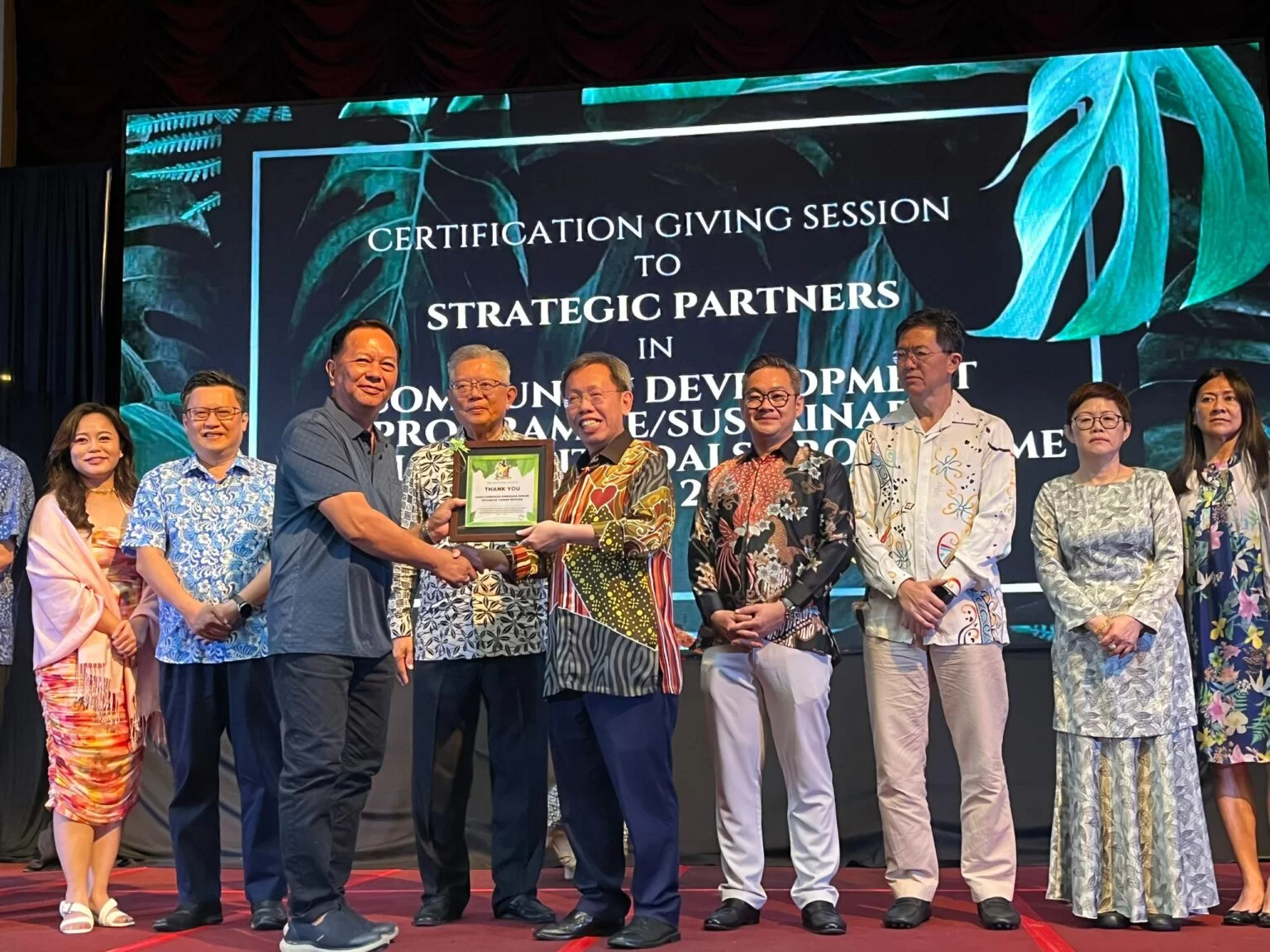 Dr Sim (left) present a token of appreciation to SMC’s strategic partner.