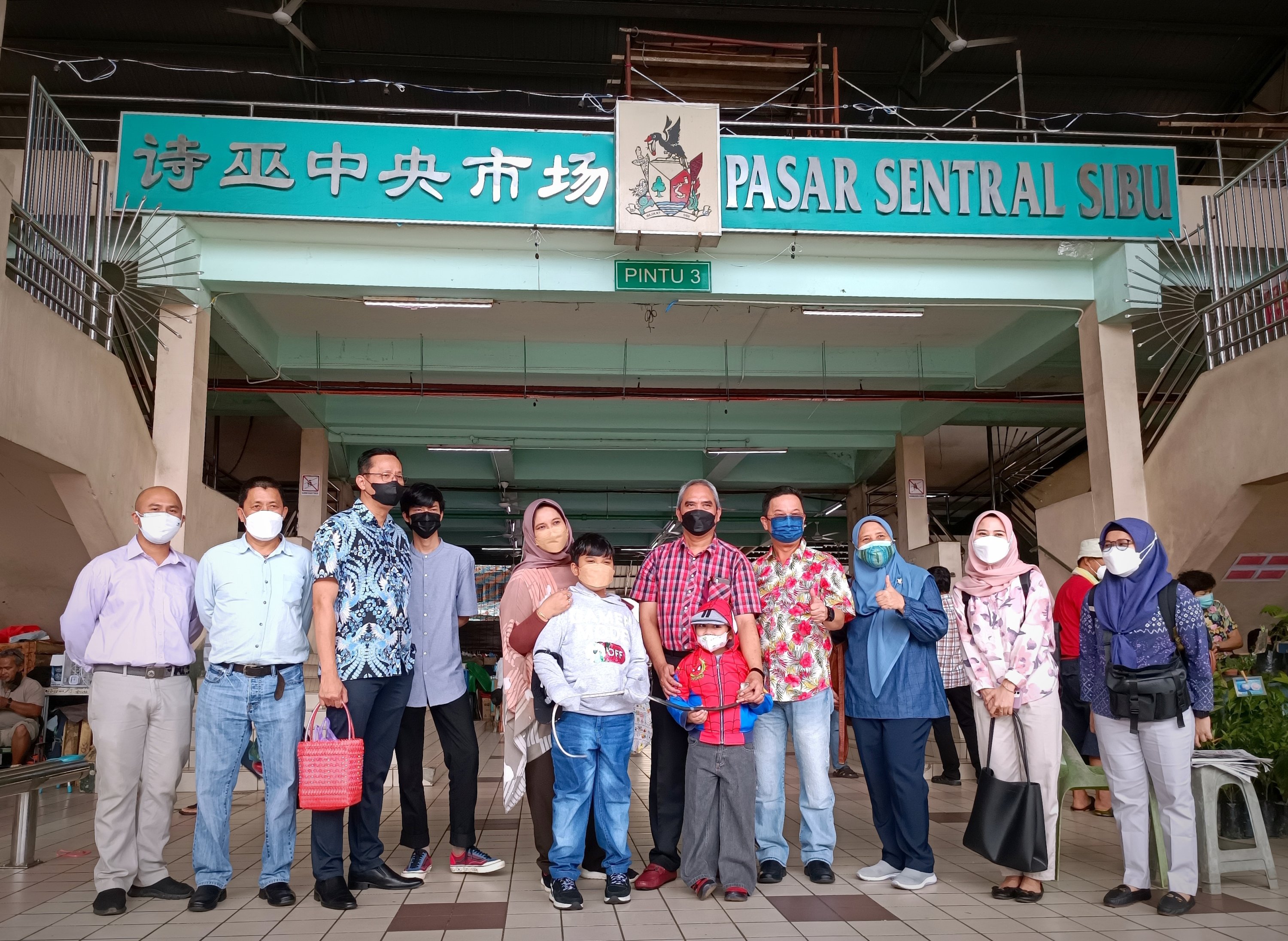 (From fourth right) Tieng, Raden and others posing for a photo session at Sibu Central Market. – Photo by Peter Boon