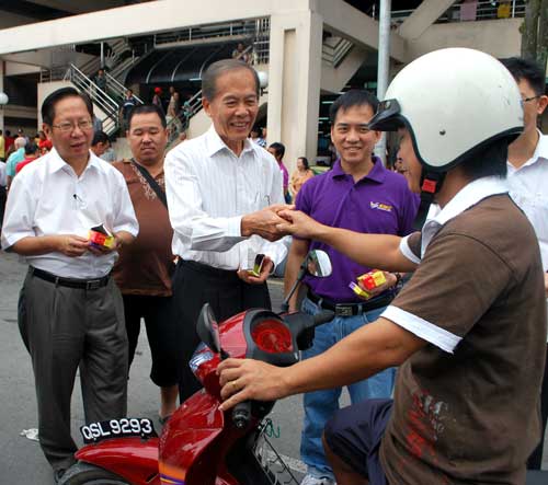 IMPROVING SECURITY: SMC chairman and Lanang member of parliament Datuk Tiong Thai King presents a padlock to a motorcyclist. At left is Temenggong Vincent Lau.