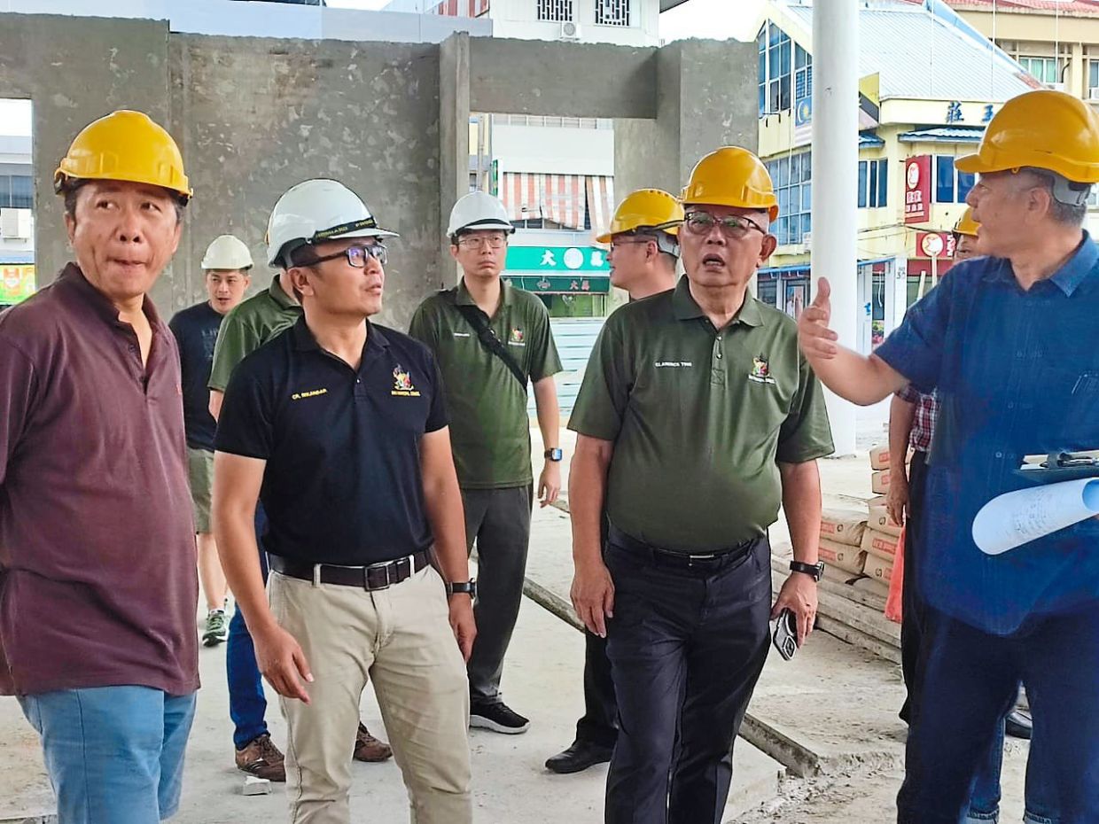 Ting (second from right) being briefed on the progress of the market project.