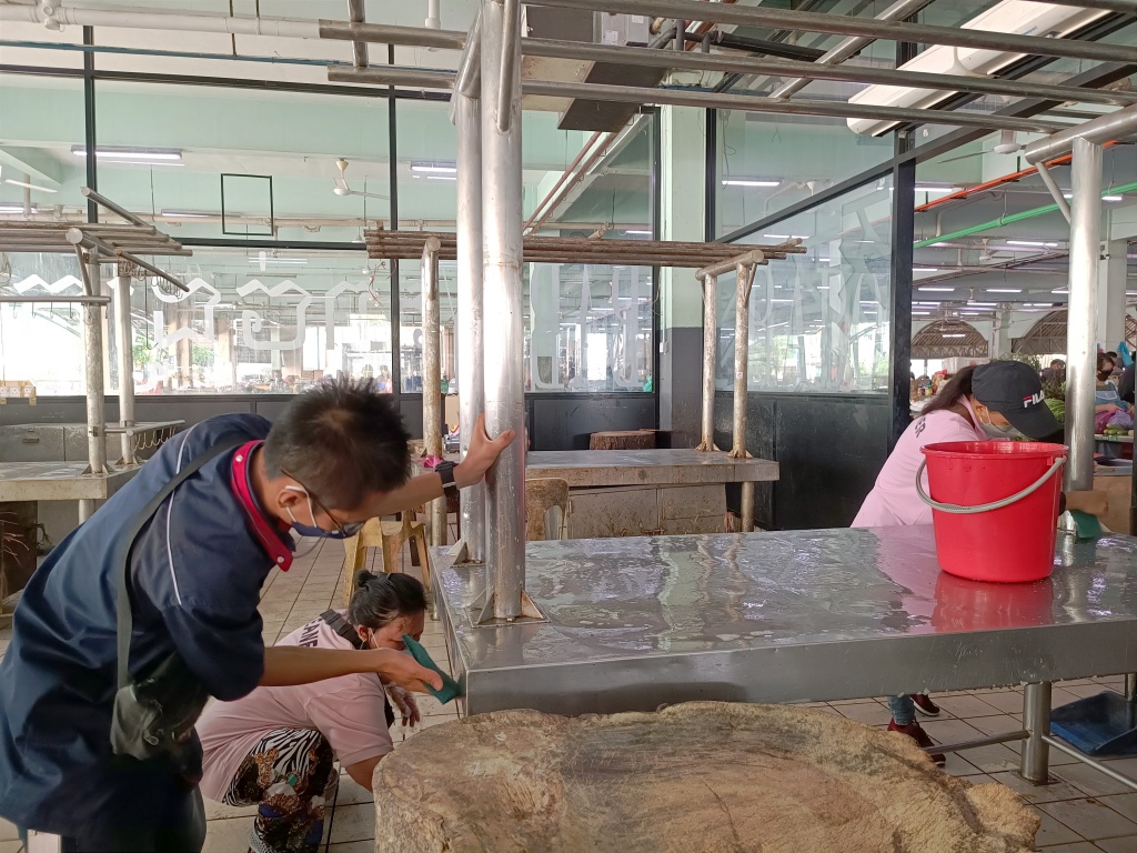 Workers cleaning the pork stalls at Sibu Central Market. – Photo by Peter Boon