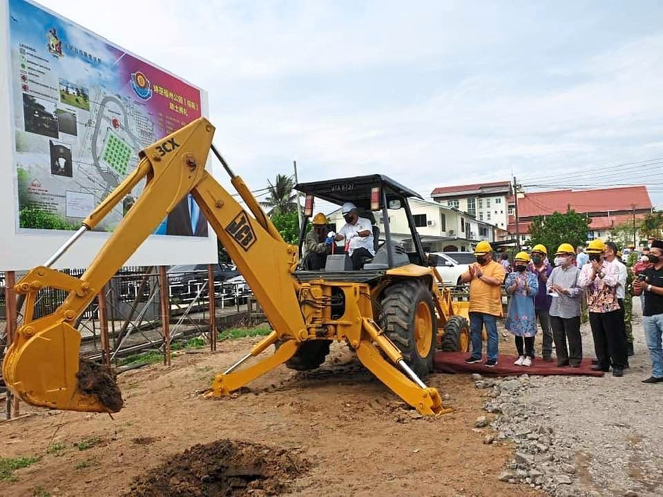 Ting carrying out the ground-breaking of World Fuzhou ShiYi Park in Jalan Gambir as Tiong (standing, left in yellow shirt) and others look on.
