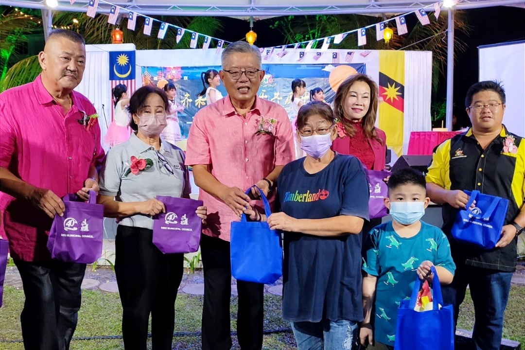 Ting (centre) and councillors distributing moon cake to the guests at the SMC’s Mid-Autumn celebration yesterday.