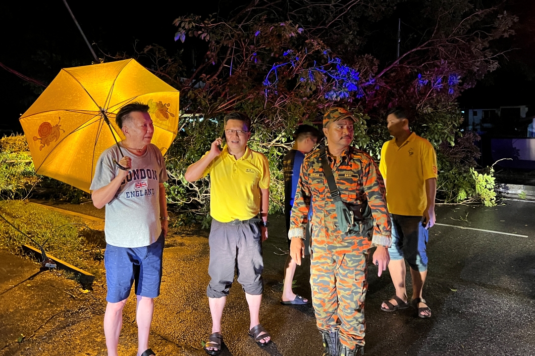 Bukit Assek assemblyman Chieng (second left) at the site of the uprooted tree at Jalan Brother Albinus.