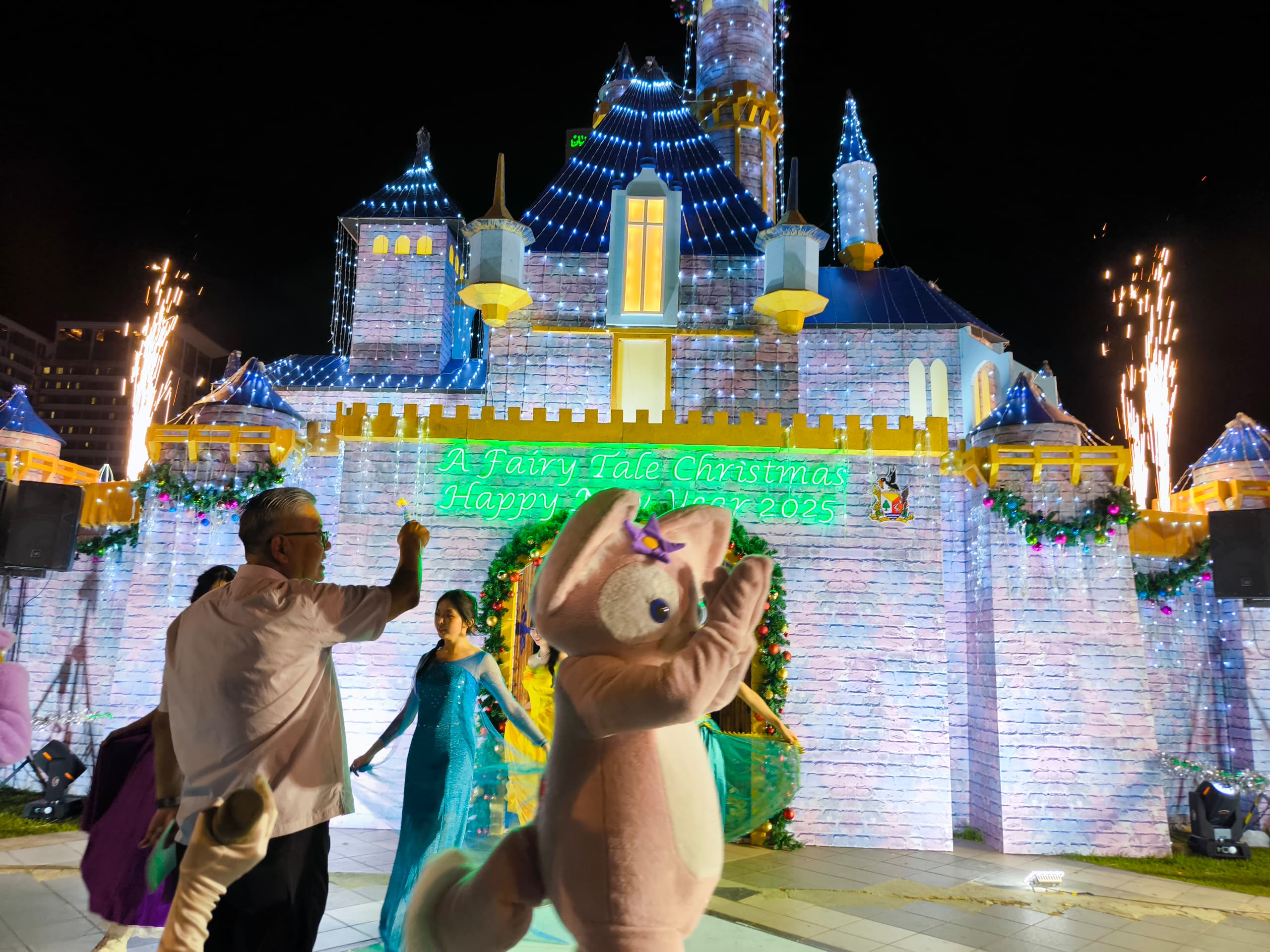 Ting uses a wand to symbolically to officiate at Christmas Festival and lighting-up ceremony. – Photo by Peter Boon