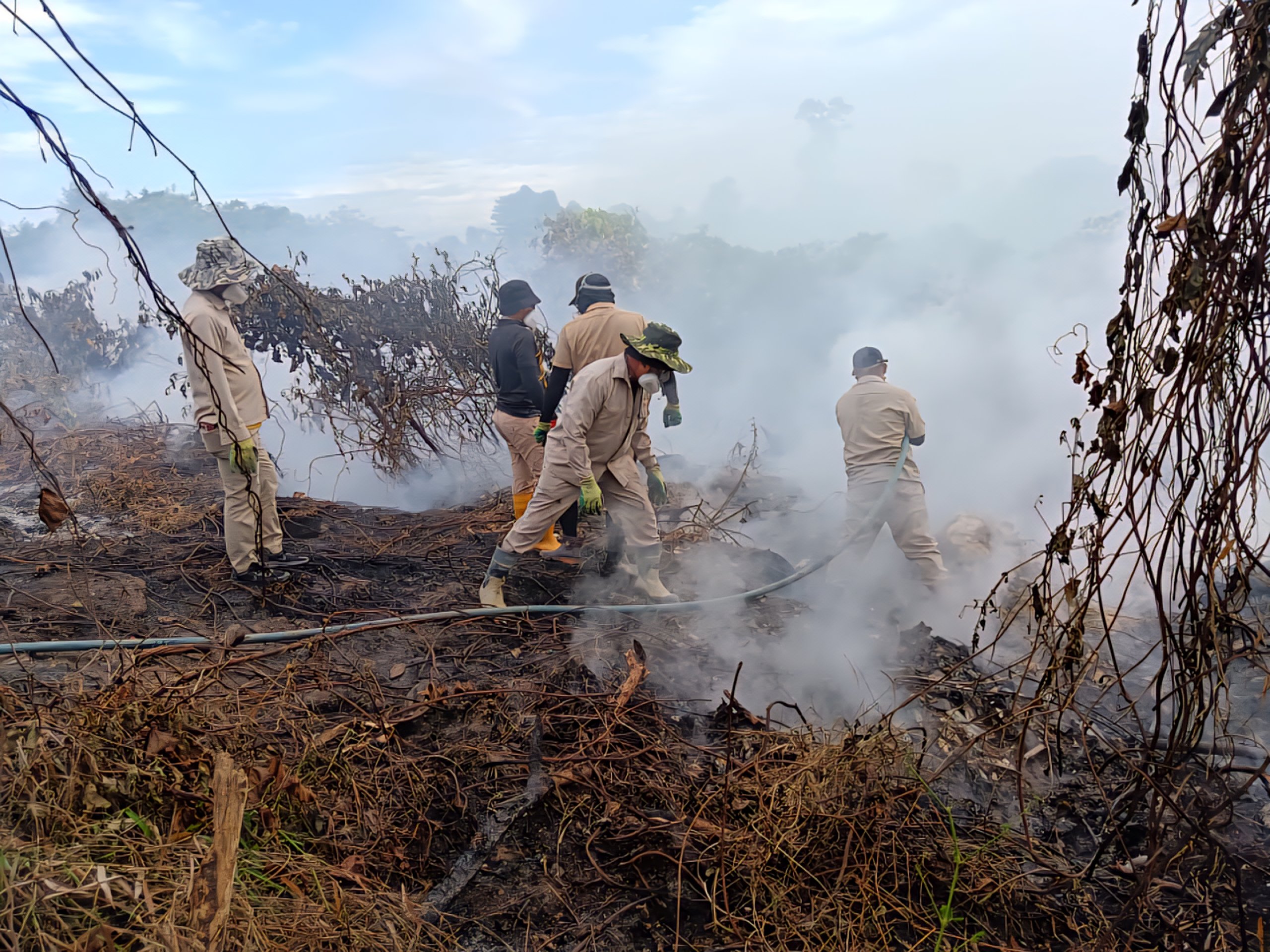 SMC workers douse flames at the closed Seng Ling dumpsite.