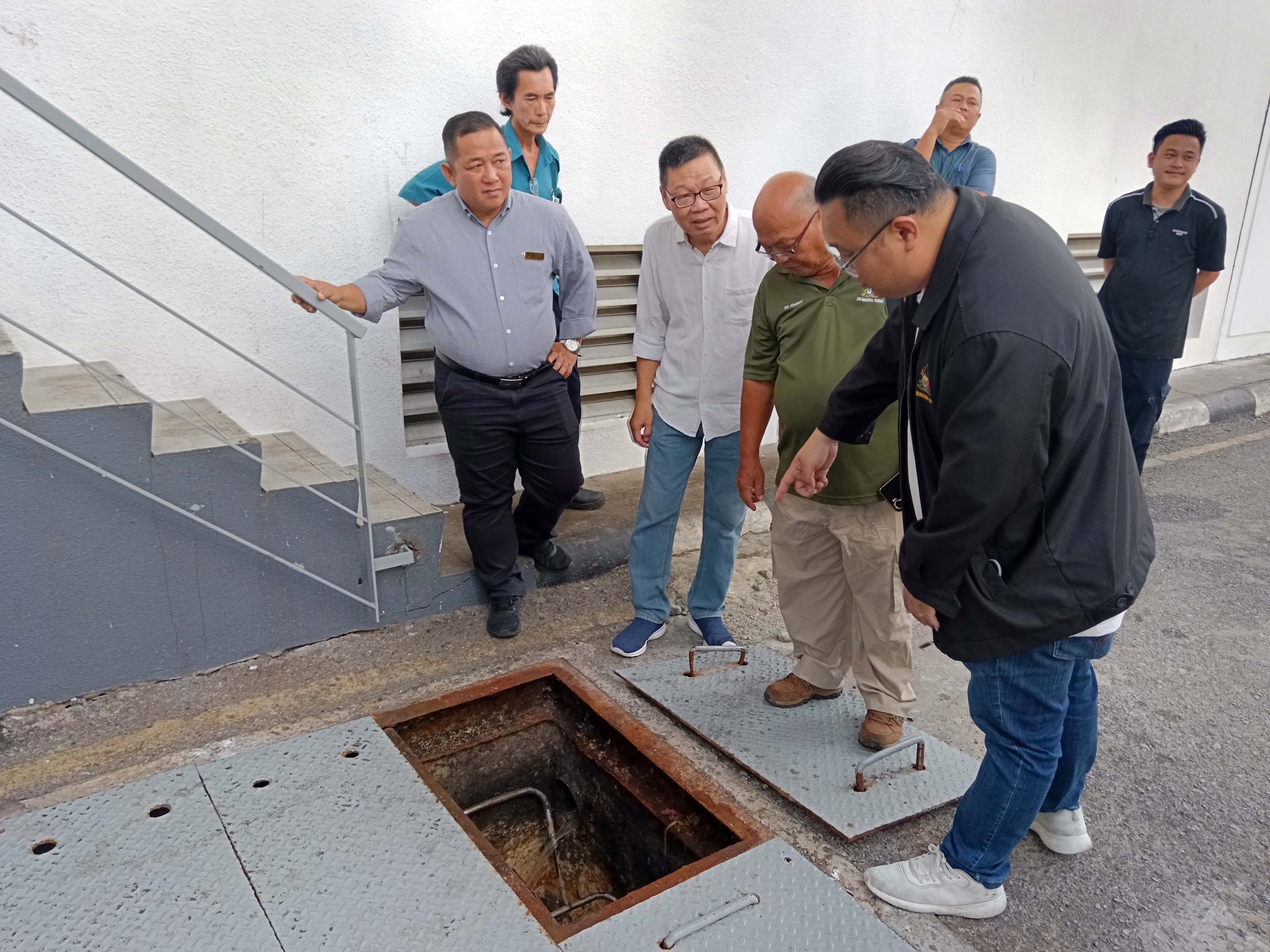 (from right) Yiing, Johnny and Yii checking the grease trap at one of the premises.