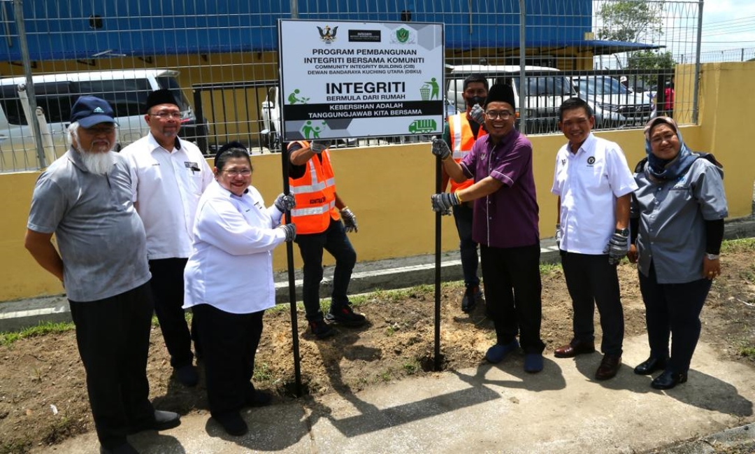 Juanda (third right) and Wan Suraya jointly set up the programme’s signboard at the community hall of Bandar Baru Samariang in Kuching. – Photo by Muhammad ​​Rais Sanusi