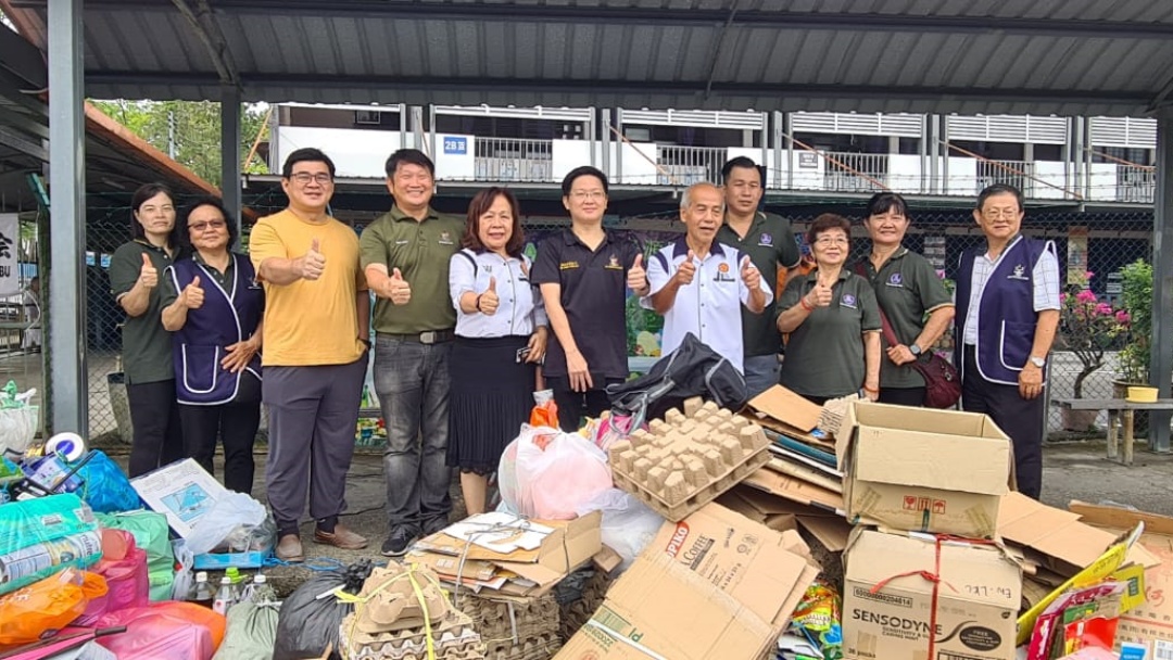 Kiing (centre) and others pose with some of the recyclables sent by the public.