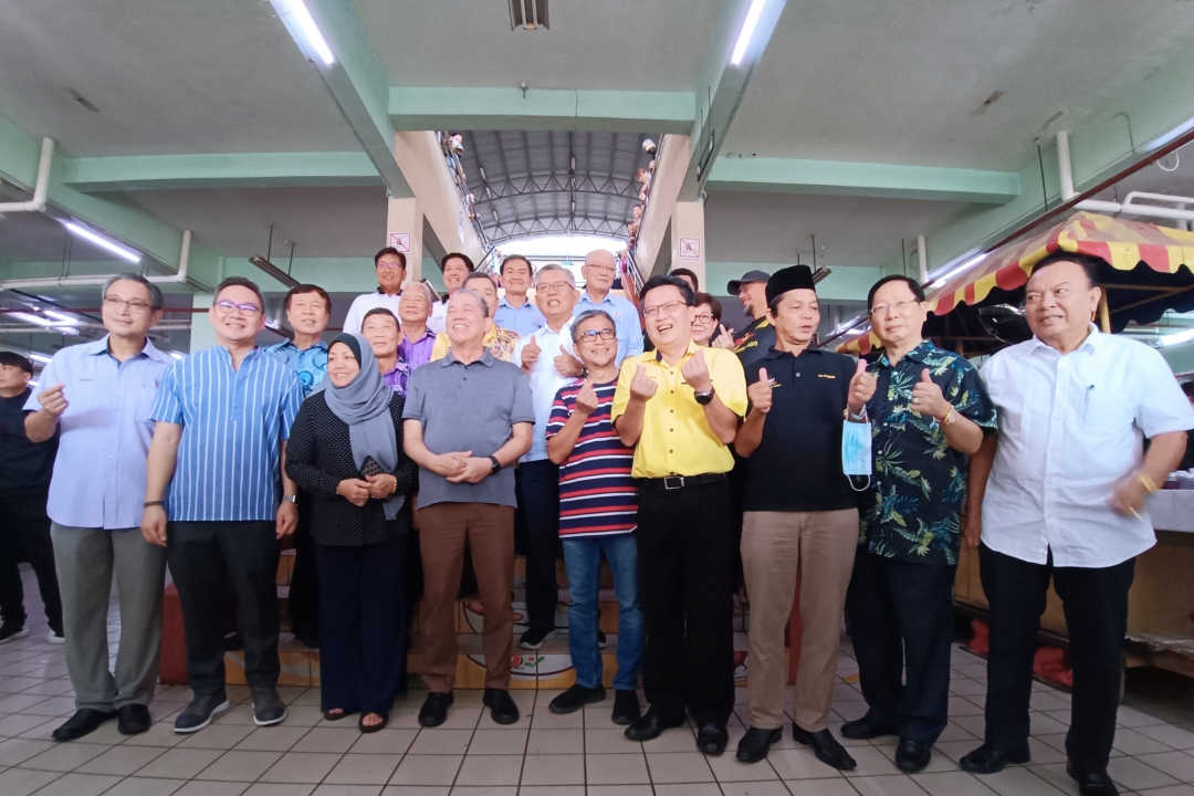 Fadillah (fourth left, front) in a photo call with and (from right) Stanley, Lau, Bujang, Chieng, Dr Annuar, and (from left) Wong, Tiang and others at the central market. – Photo by Peter Boon