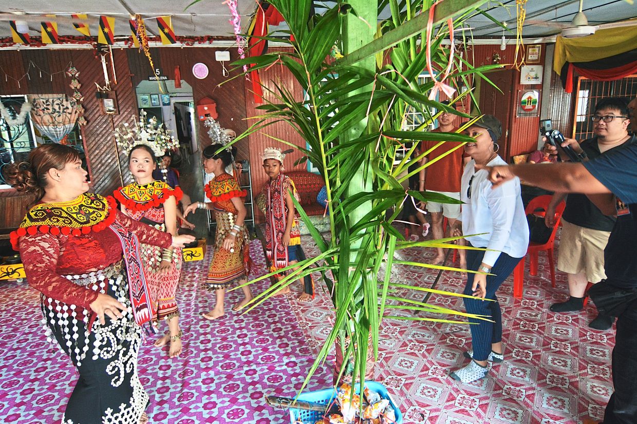 Lydia (left) leading the Ngajat dance with her family and visitors around the Ranyai tree.