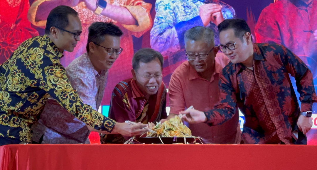 (From left) Izkandar, Chieng, Sim, Ting, and Tiang toss the ‘Yee Sang’ at the celebration gathering.