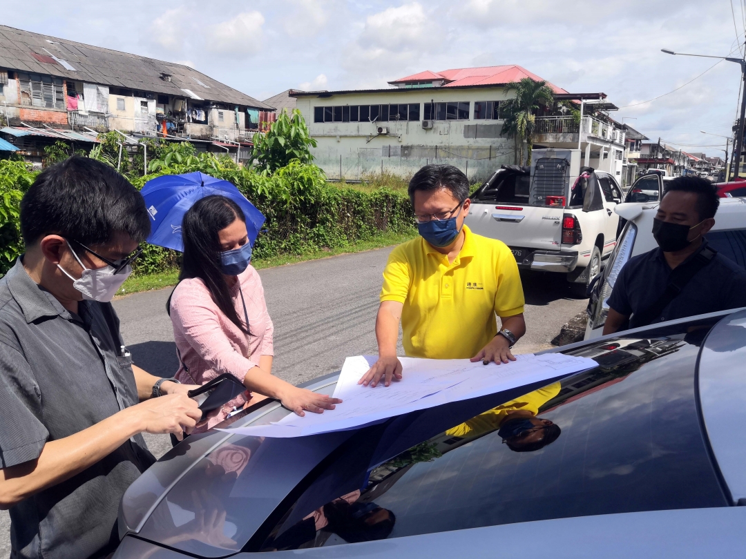 Chieng (second right) studies the map during his visit to the project site.