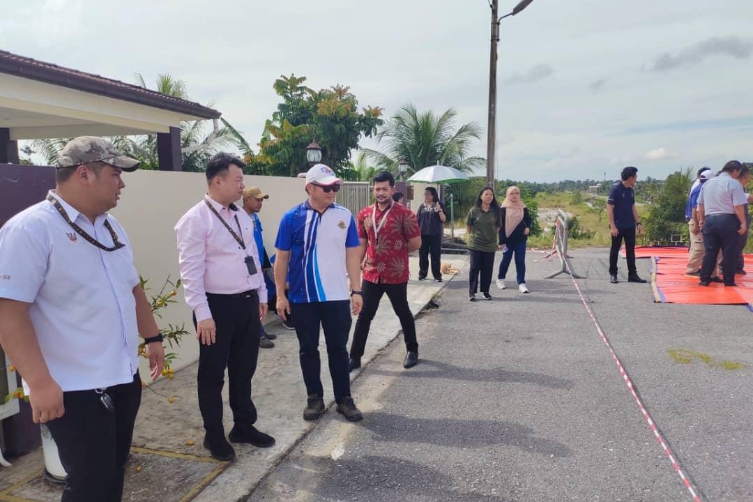 The officials assess the landslide situation at Lorong Rantau Panjang Jaya 7 today.