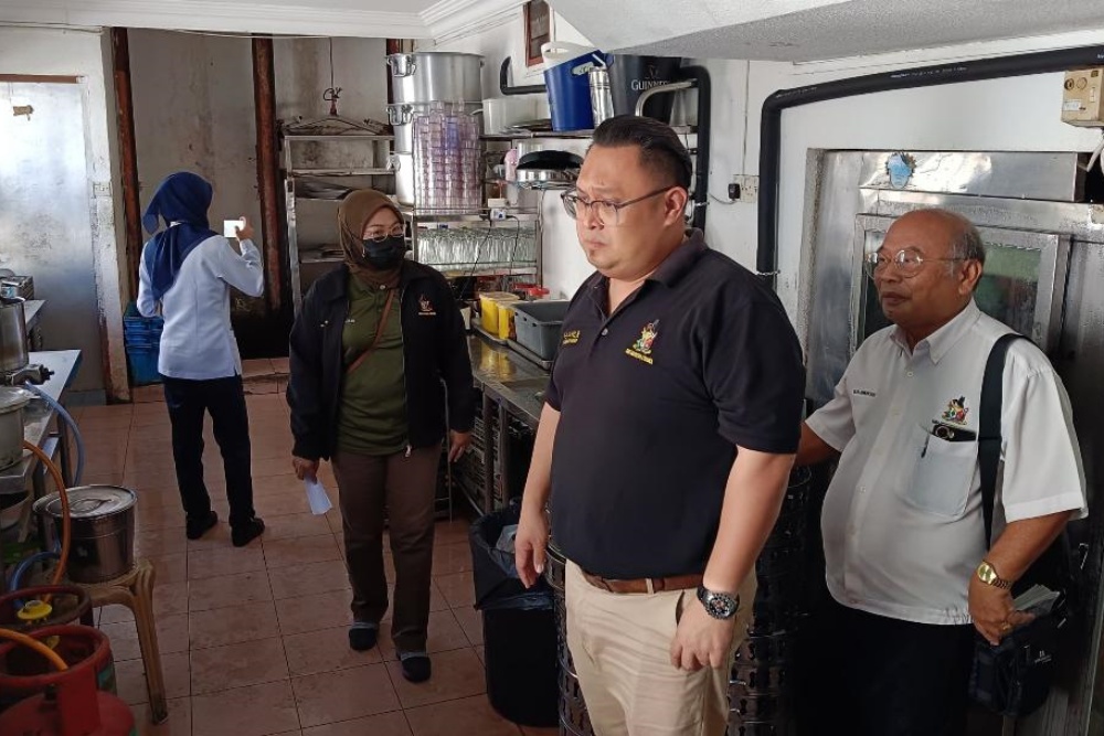 Yiing (second right) and his team members inspecting the kitchen of the food premises.