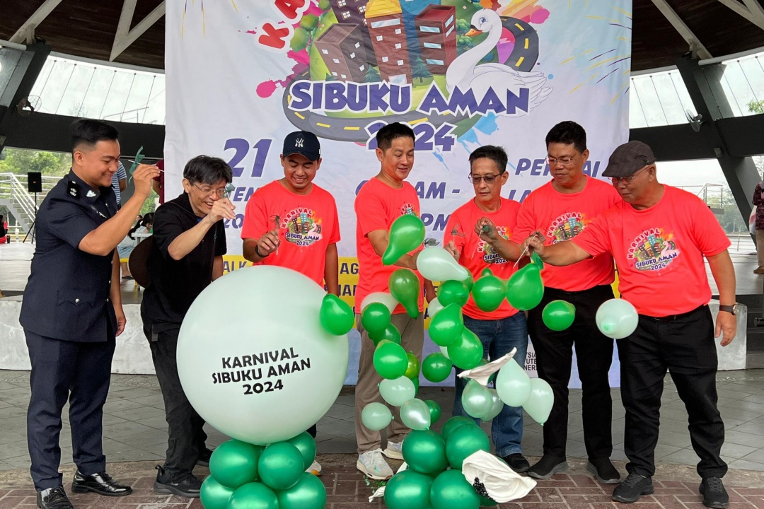 (From third left) Raden Khairulzaman, Albert, Yong and others burst the balloons to open the carnival.
