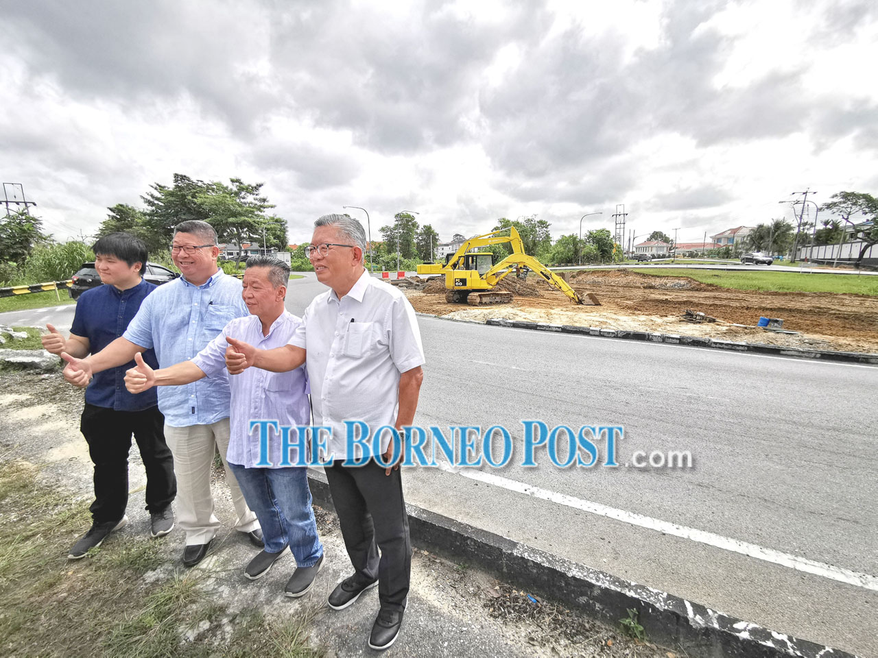 (From right) Clarence, David, Roland and Samuel show their thumbs-up during a photo-call at the traffic light project site at the Ling Kai Cheng-Ulu Sungai Merah Road roundabout.