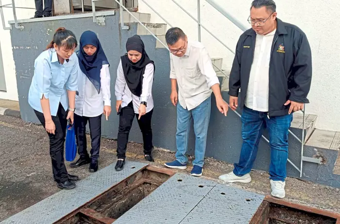 Yiing (right) with staff checking on missing drain covers.